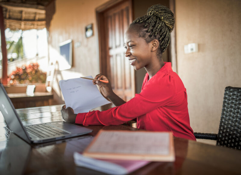 Young black beautiful woman using laptop and phone