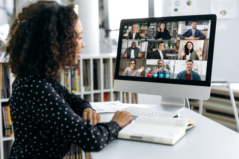 African american business woman, sits in front of a computer screen, talks via video link with international colleagues, employees, discusses a future project, perspective, business strategy, plan