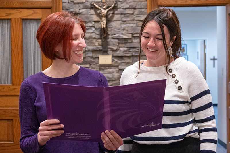 Financial Aid officer holding folder and showing to smile student